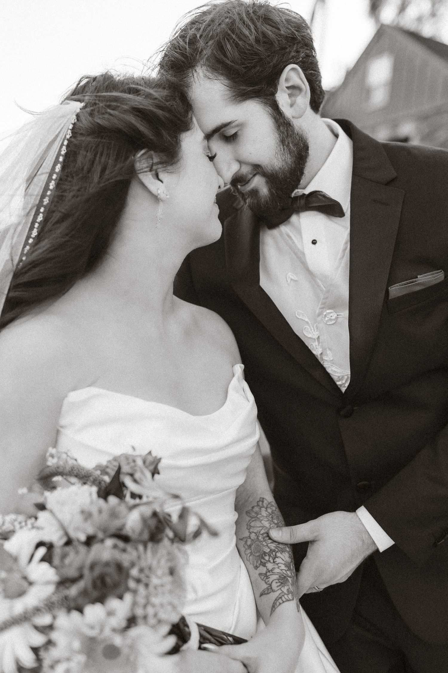 A romantic black and white wedding photo series showing intimate moments between newlyweds sharing tender kisses.