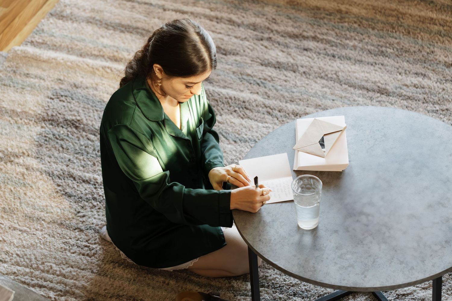 Student studying at a round table with books and papers spread out.