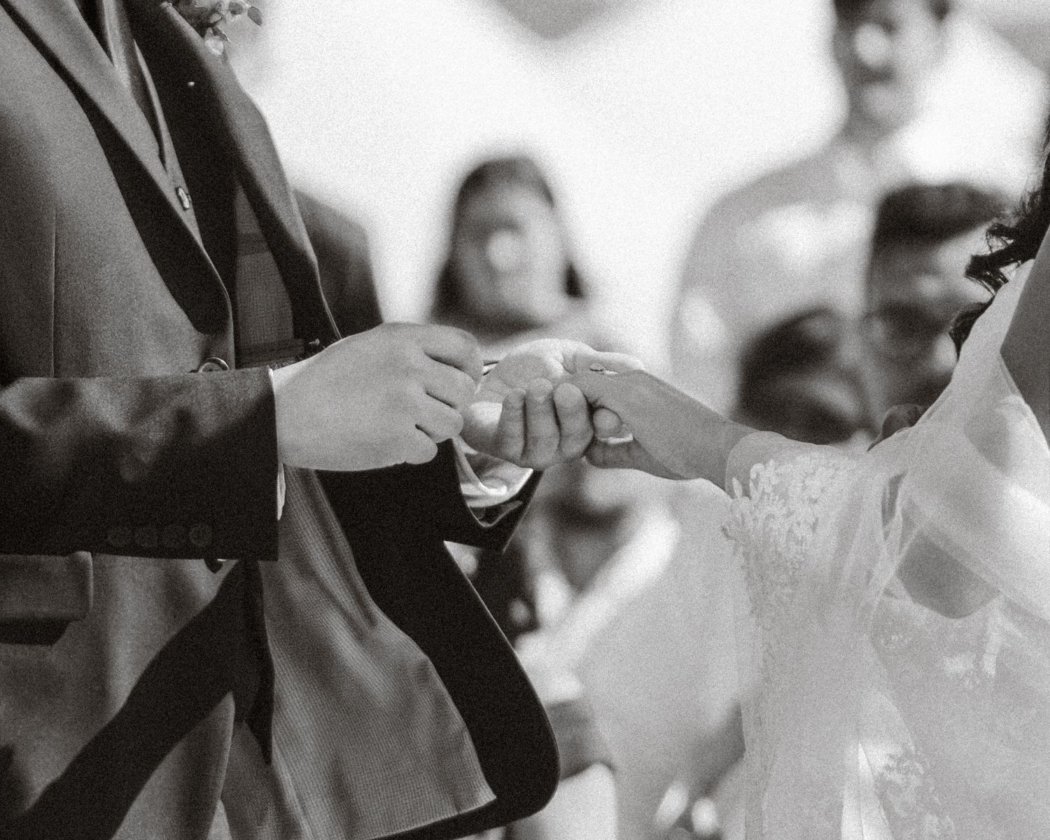 Black and white wedding ceremony photo showing guests seated in rows.