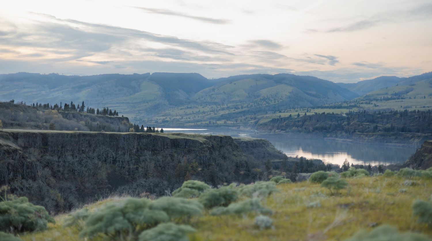 Scenic mountain landscape panorama with lake and forested hills extending to the horizon.
