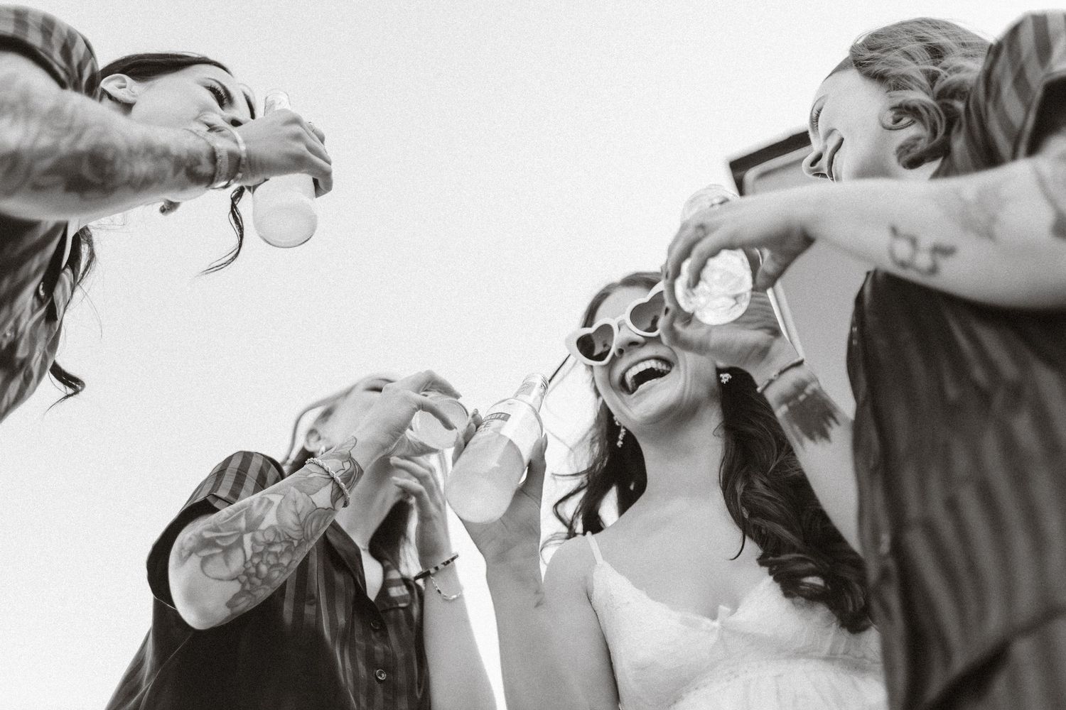 A series of black and white photos showing champagne being poured and toasted at a celebration.