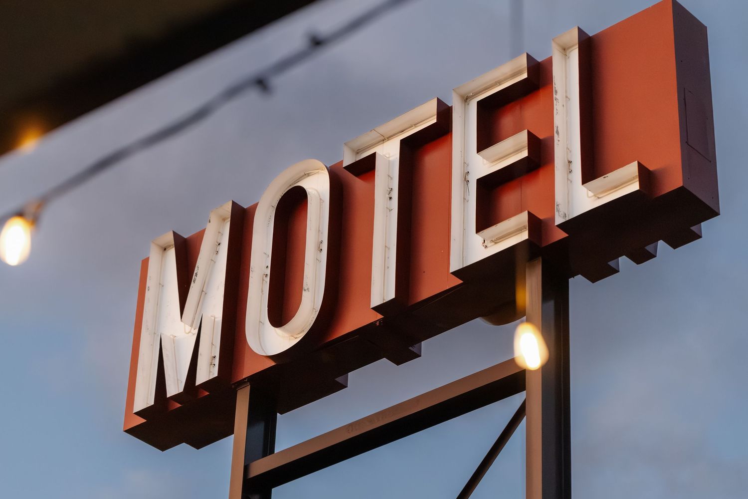 Vintage red motel sign against a blue sky with retro lettering and design.