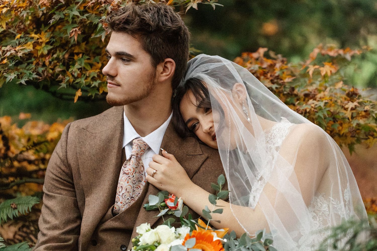Romantic autumn wedding scene with fall foliage in the background.