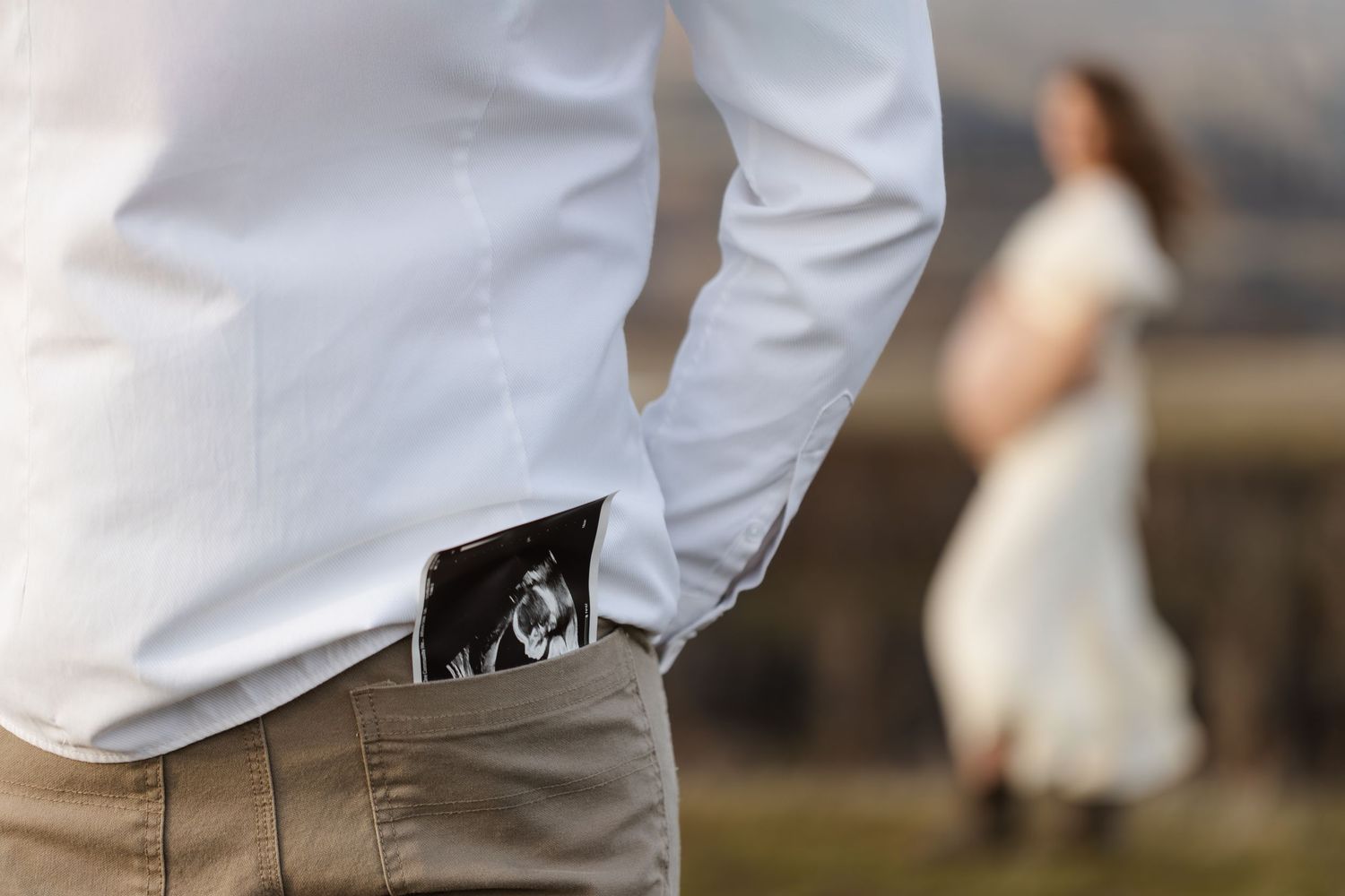 Person in white clothing walking outdoors against a blurred background.