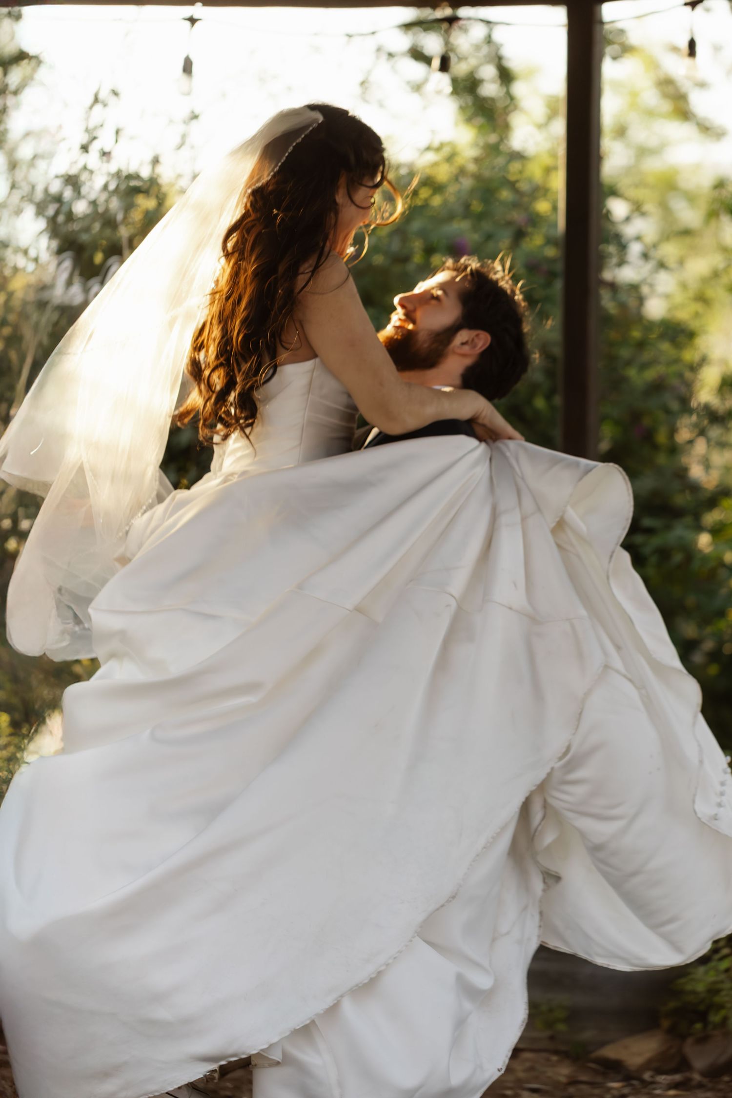 A romantic sequence of wedding photos showing a couple dancing and twirling in white wedding attire outdoors.