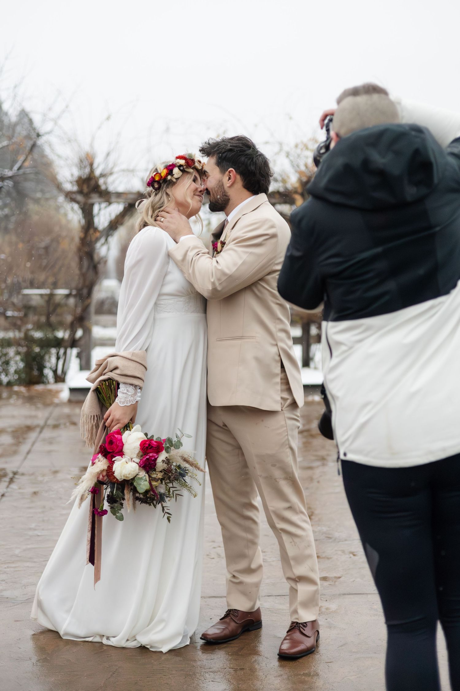 A romantic winter wedding scene with a couple in beige and white sharing an intimate moment.
