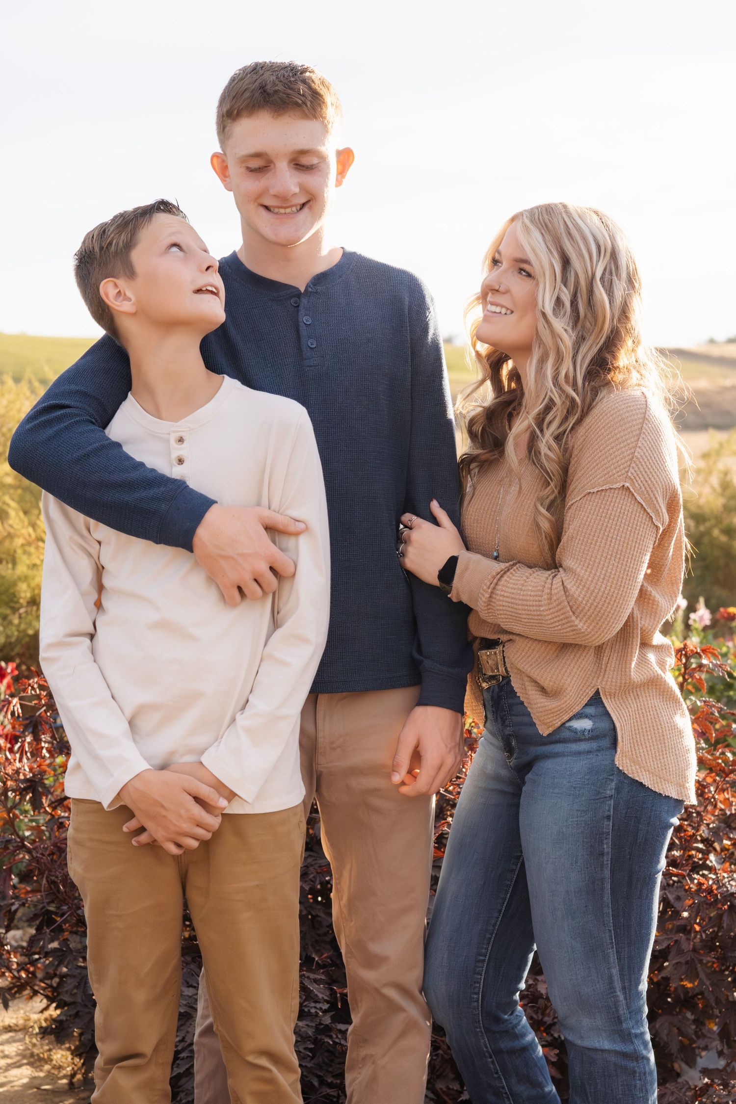 Casual family portrait with coordinated outfits in warm earth tones.