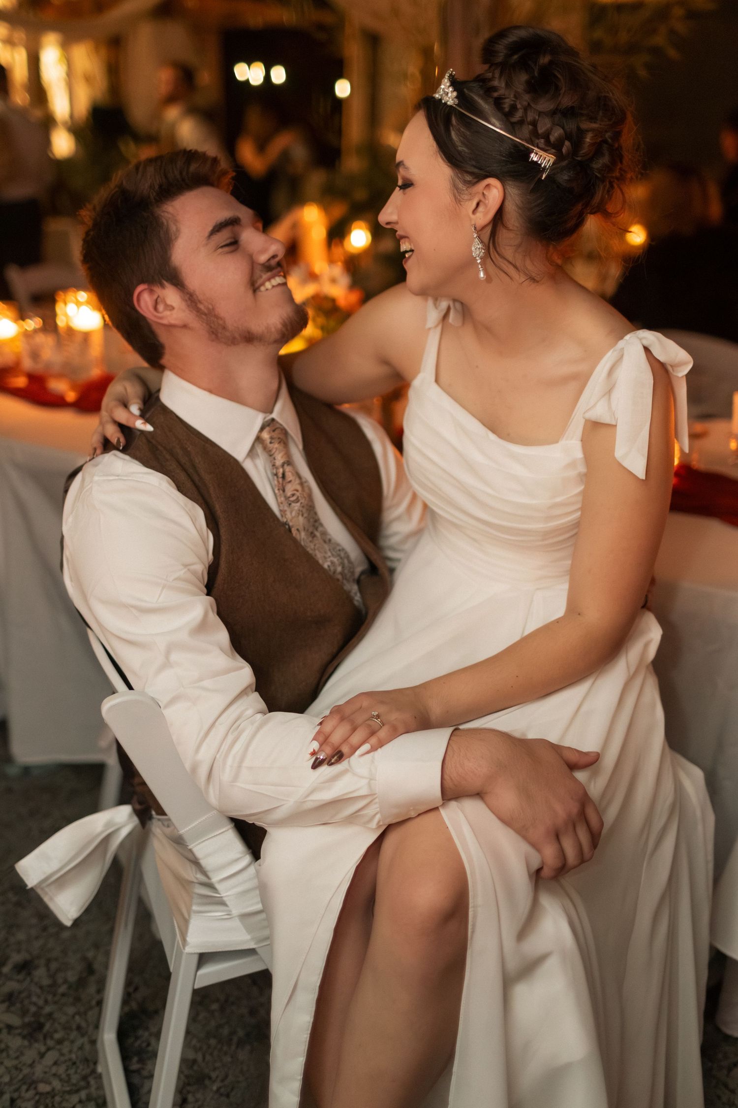Intimate moment between couple during wedding reception at candlelit venue.