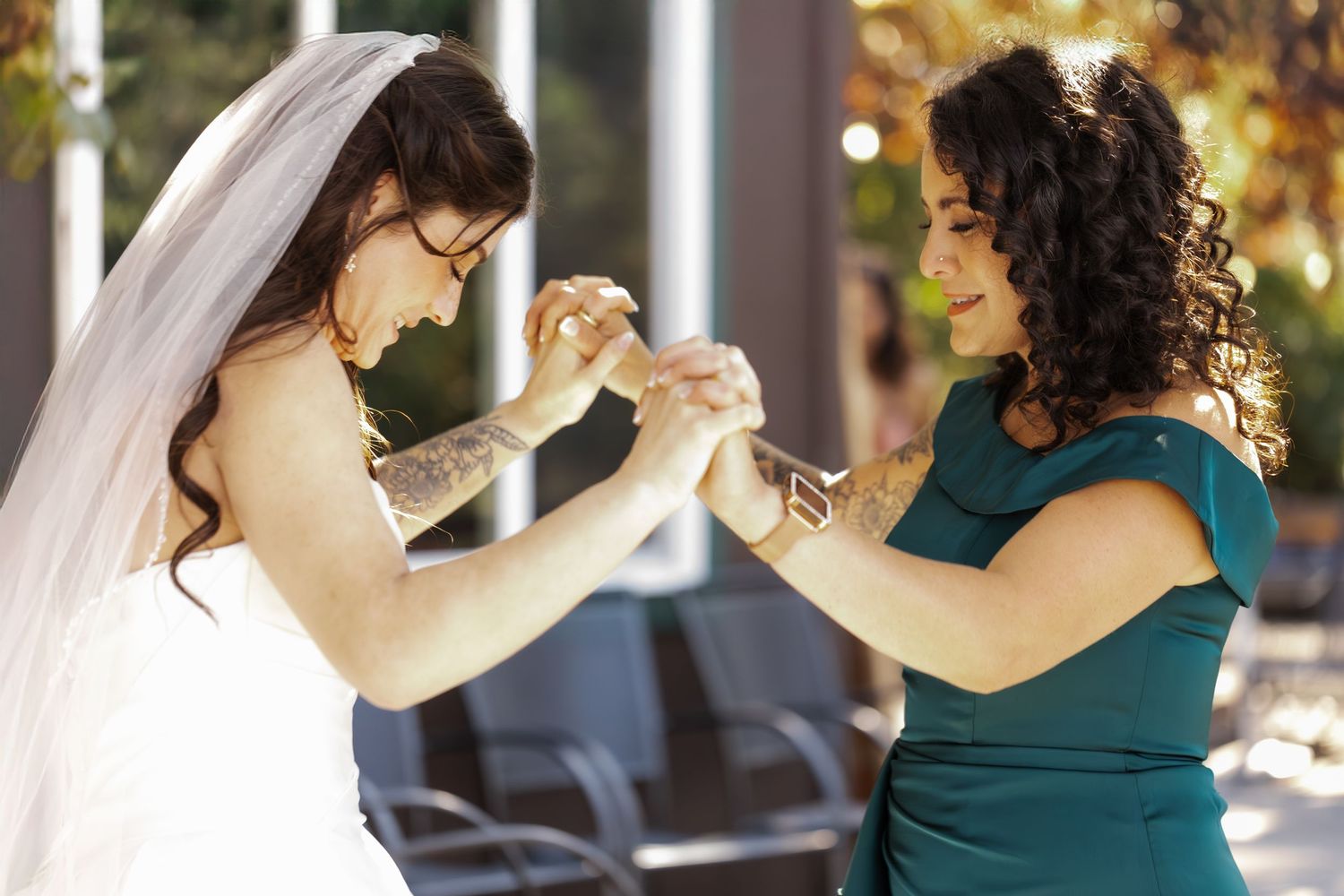 A couple dances intimately in formal attire against a bokeh background at an indoor venue.