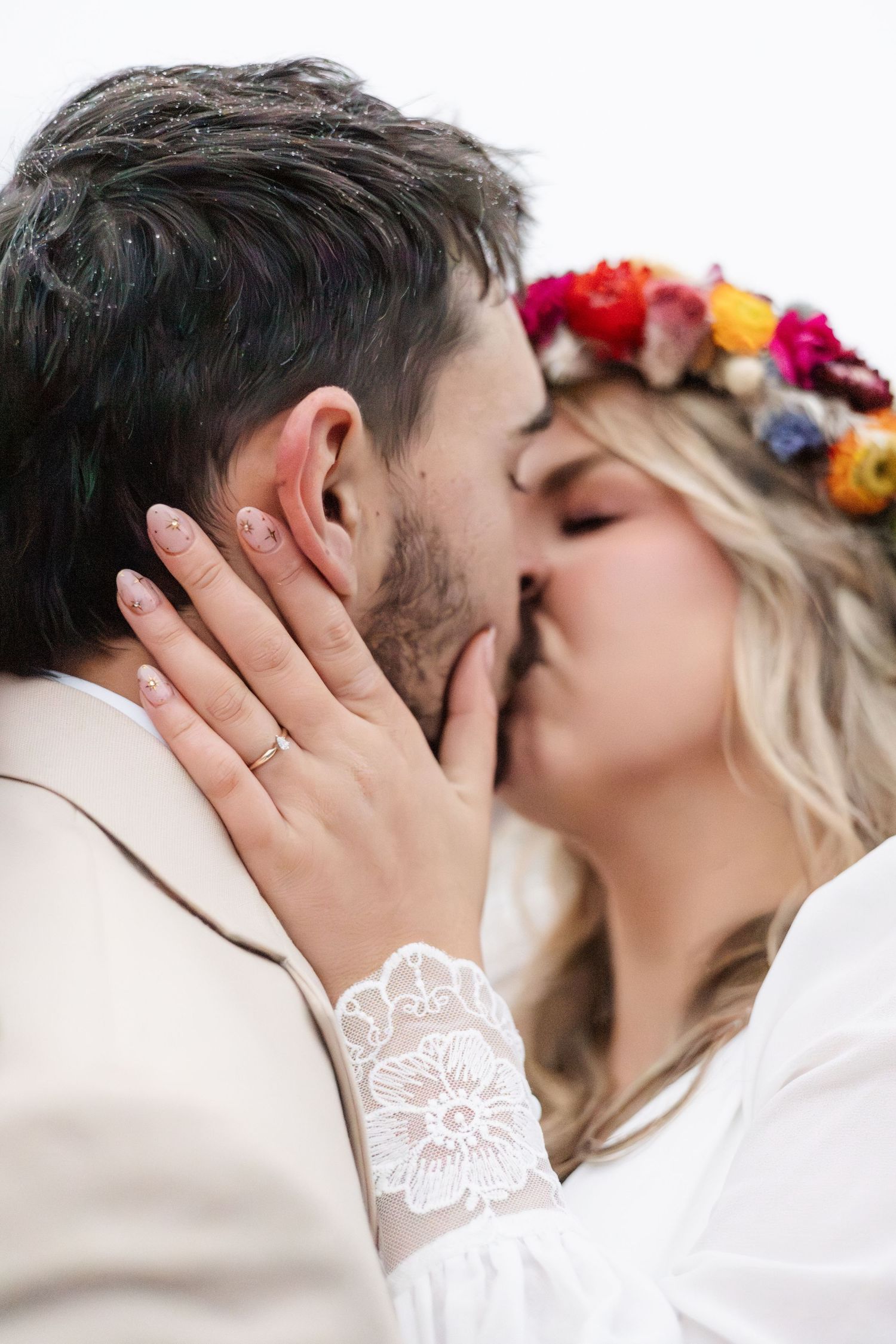 Romantic moment captured with floral crown and lace sleeve details.