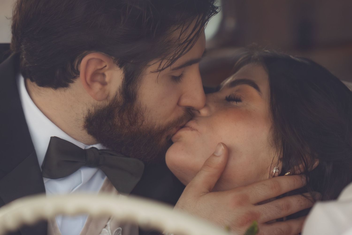 Romantic couple sharing intimate kisses in warm lighting.