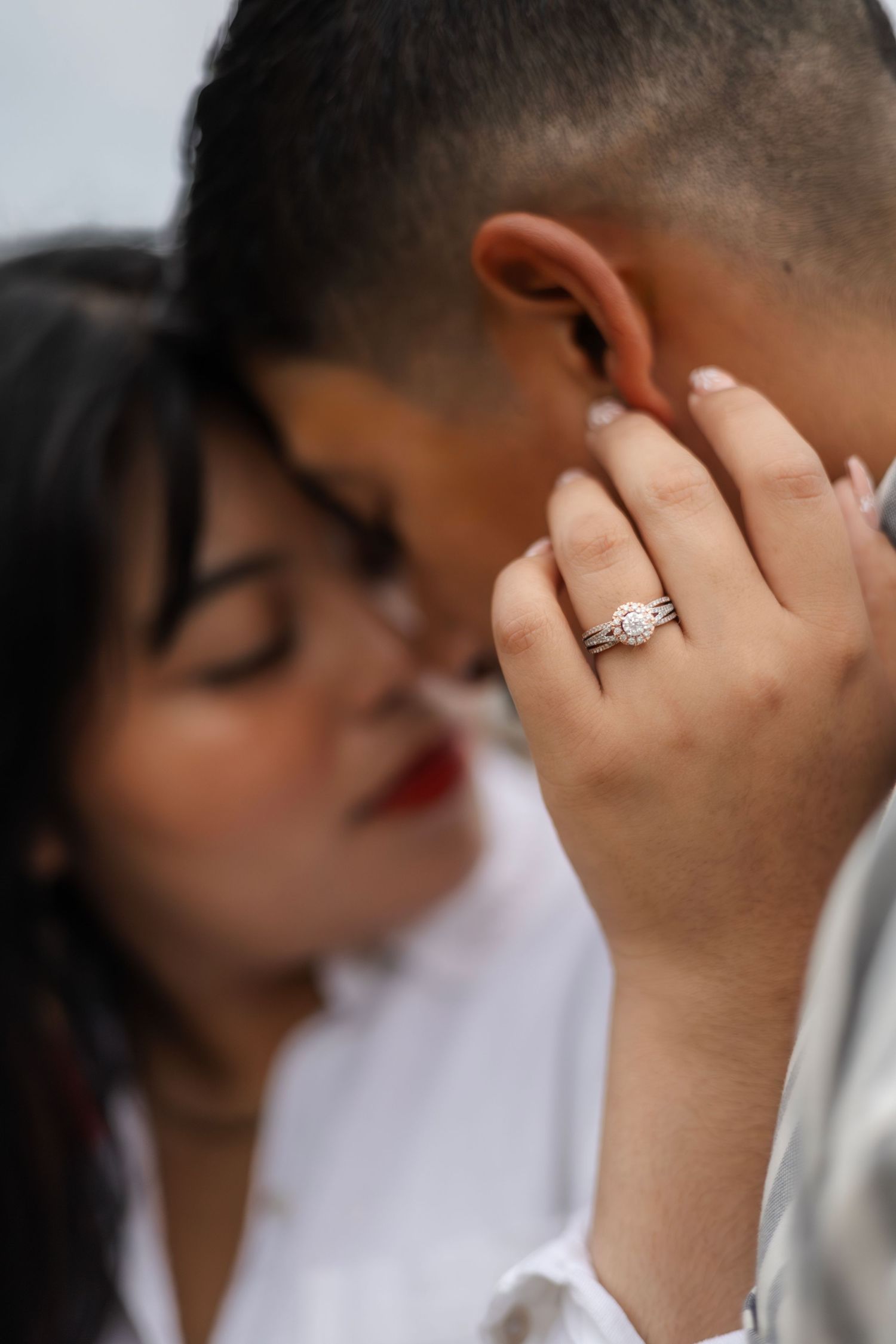 Close-up engagement ring shots with couple sharing tender moments in background.