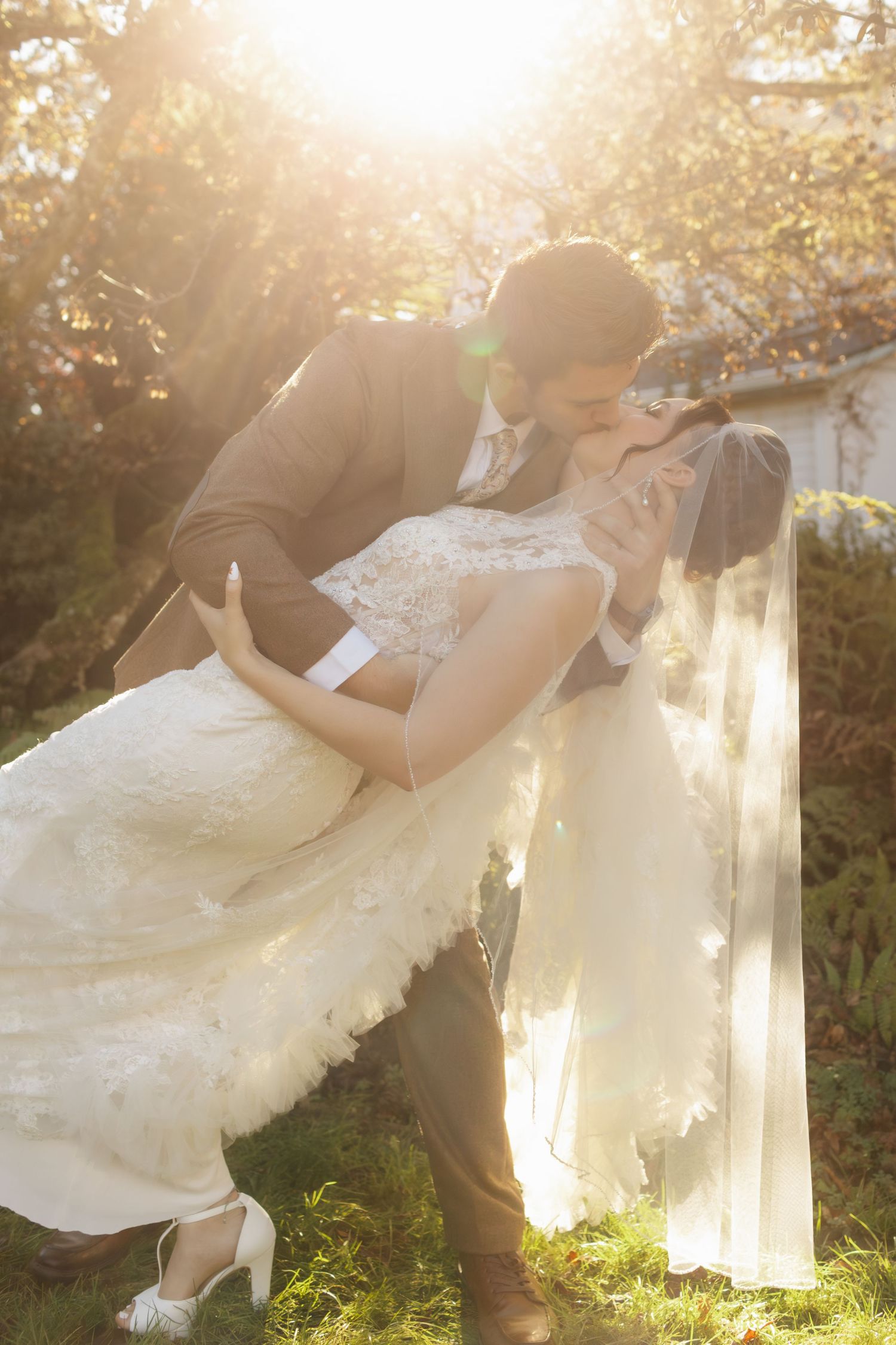 Dreamy sunset wedding photos showing a couple embracing in a garden with golden light filtering through trees.