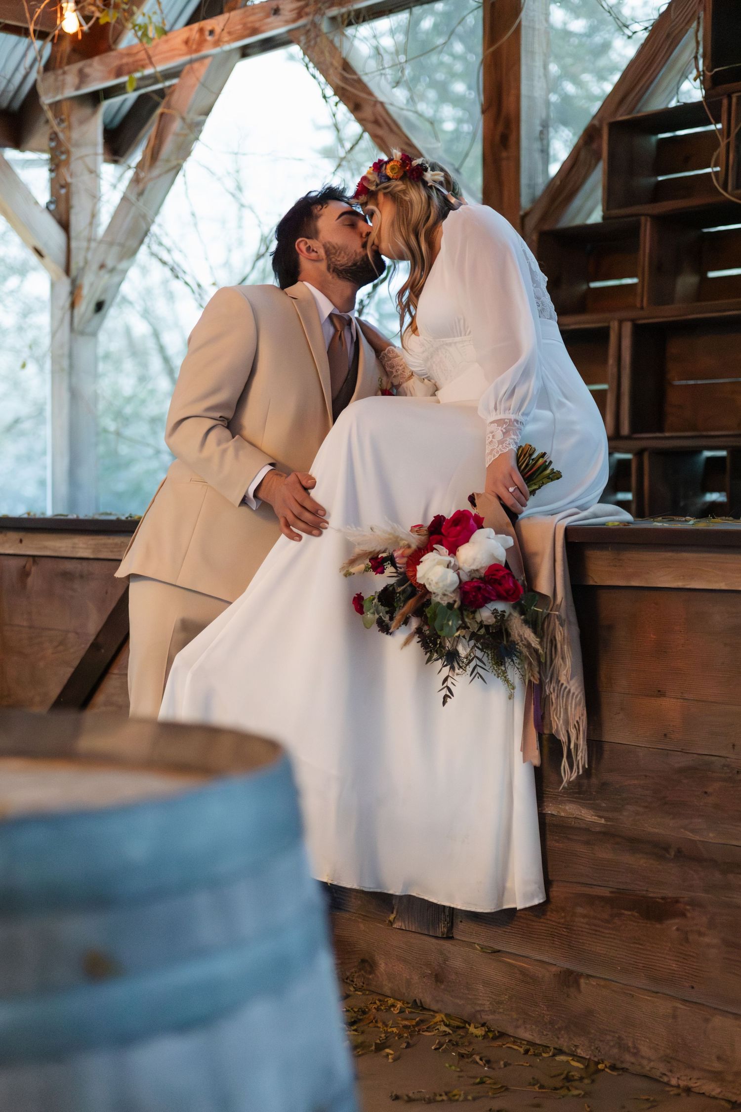 Rustic barn wedding scene with wooden beams and romantic lighting.
