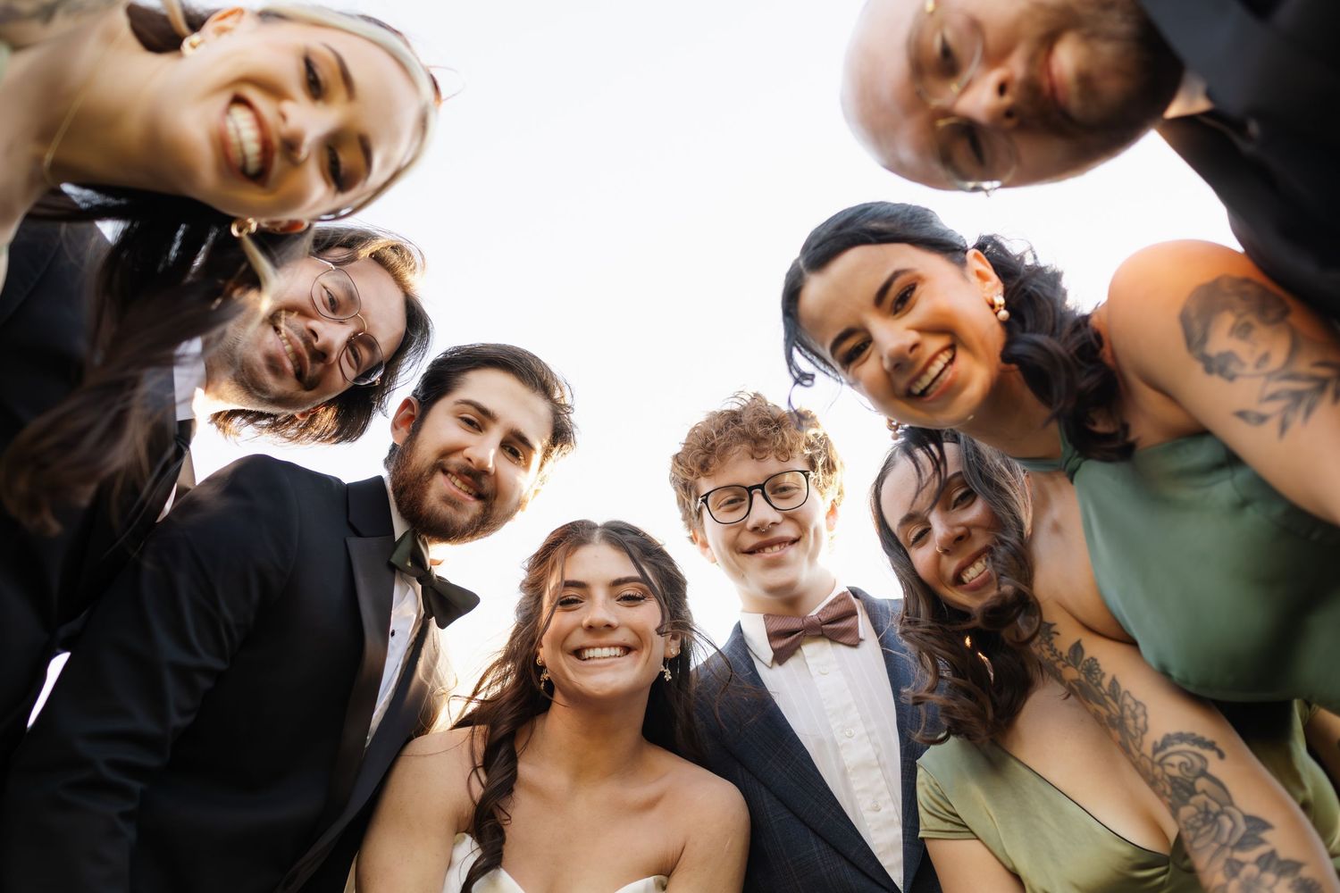 Wedding party members pose together in a playful group photo series.