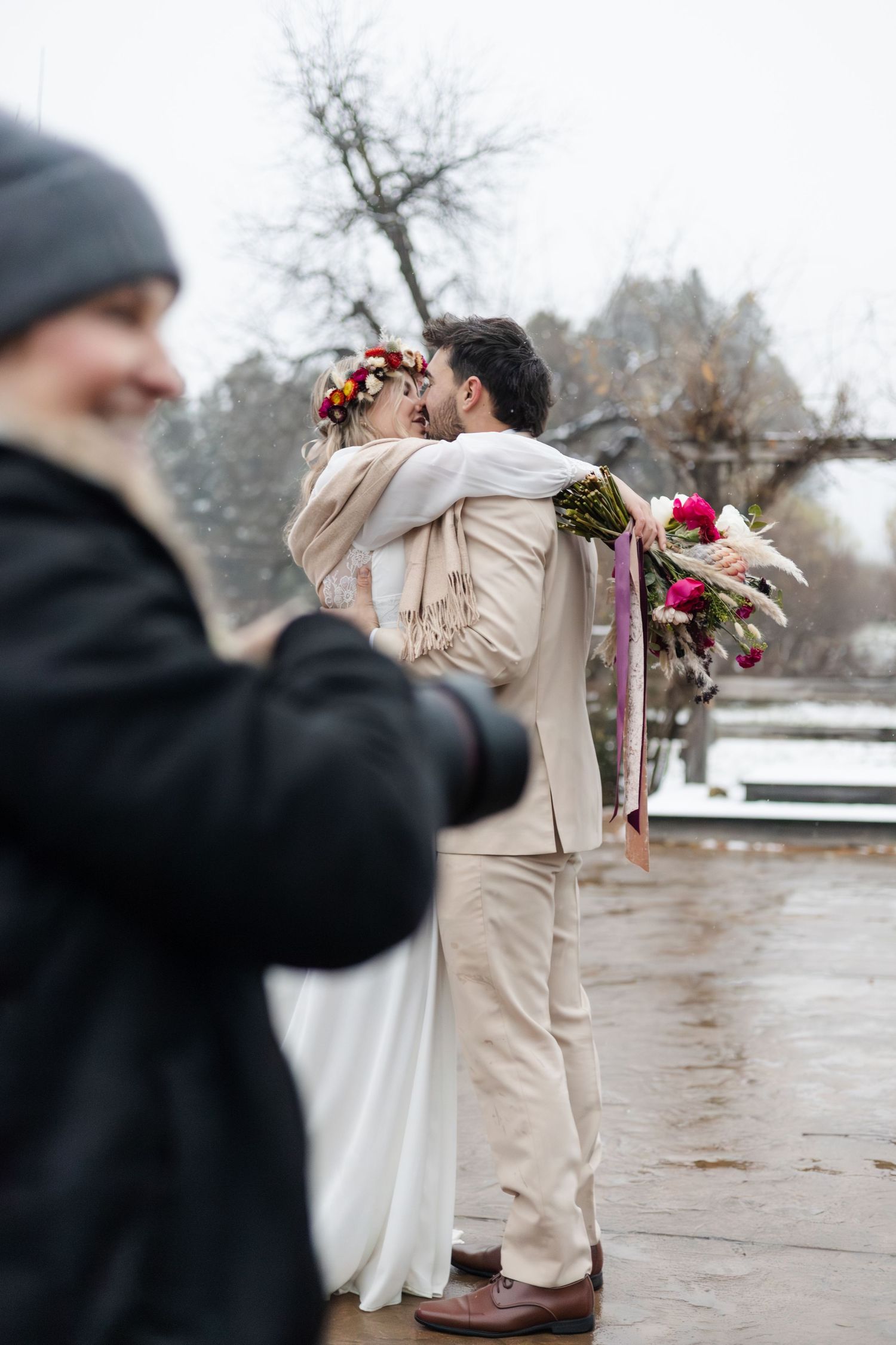 A winter wedding moment captured from behind as photographers document the special day.