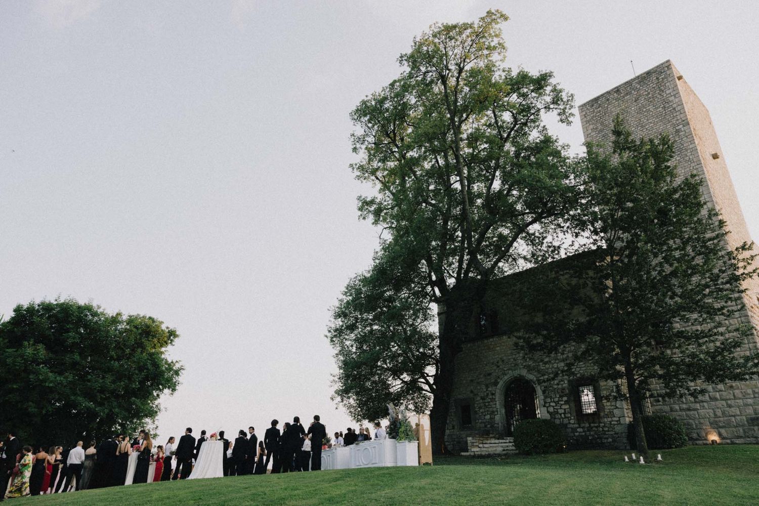 A series of panoramic photos showing a historic stone church building and gathering on a grassy hillside.