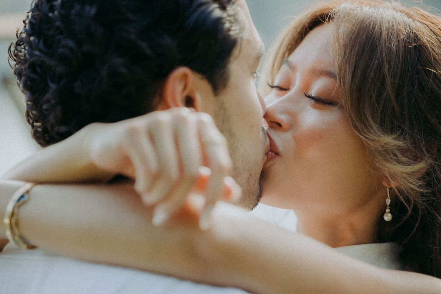 A romantic couple shares a tender kiss in a close-up black and white photograph.