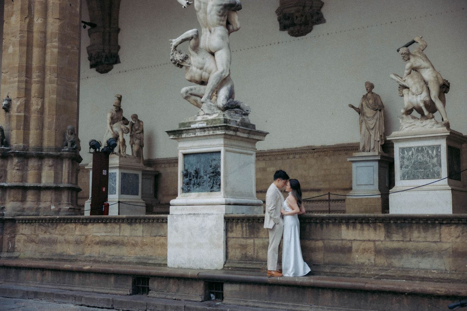Classical stone architecture with ornate statues and columns in a historic European setting.