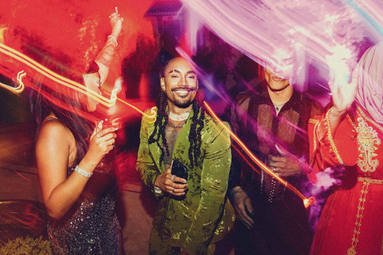 People dancing and socializing at a vibrant nightclub with red and purple lighting effects creating an energetic atmosphere.