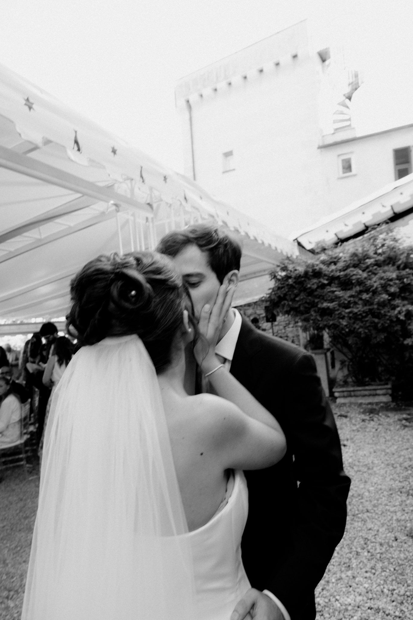 A romantic black and white wedding photo sequence showing a couple sharing a tender kiss outdoors.