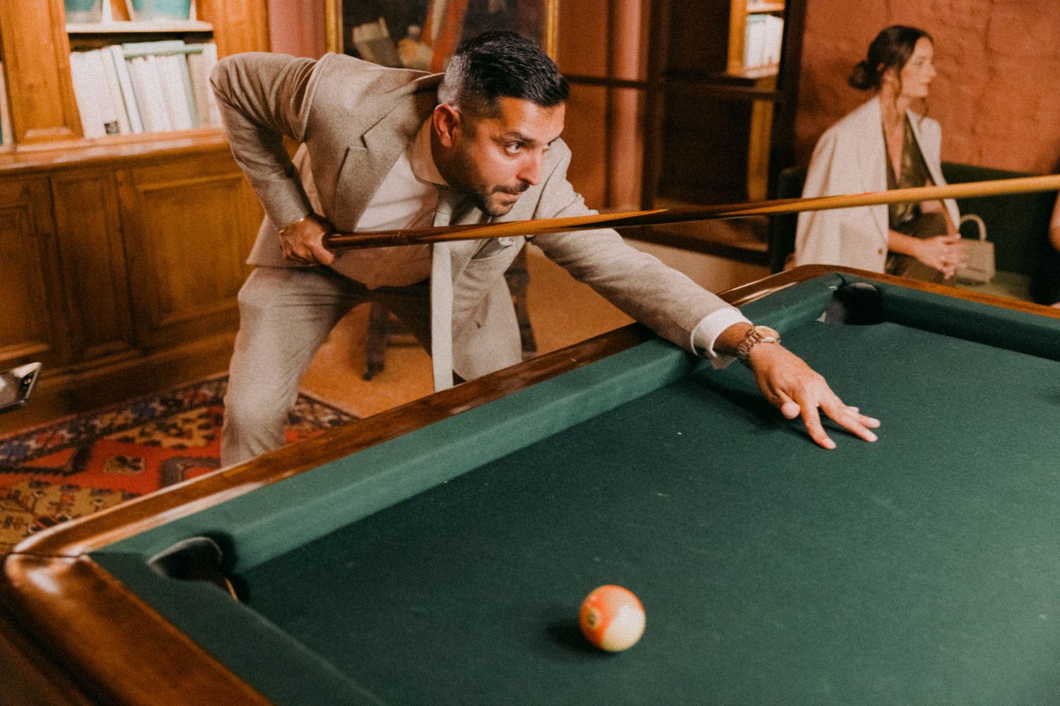 A sequence of action shots showing someone playing pool in a warmly lit room with wooden paneling.