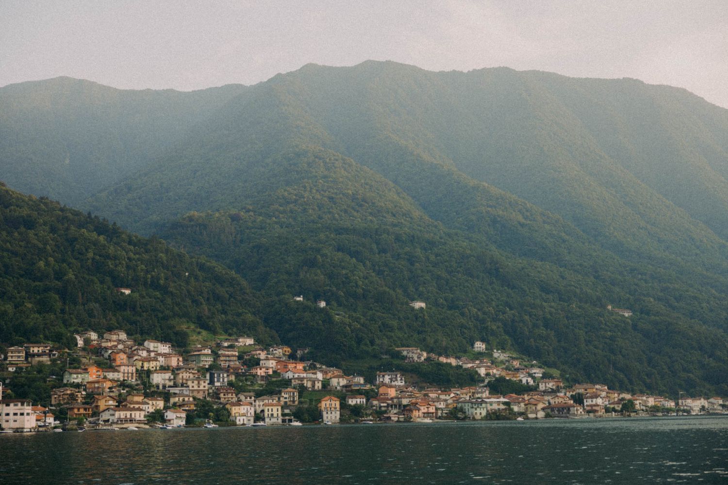 Panoramic view of coastal buildings nestled along the mountainous shoreline of Montenegro.