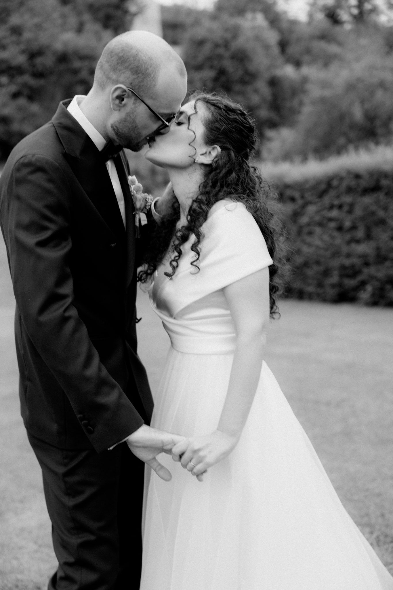 Black and white romantic wedding photo series showing intimate moments outdoors.
