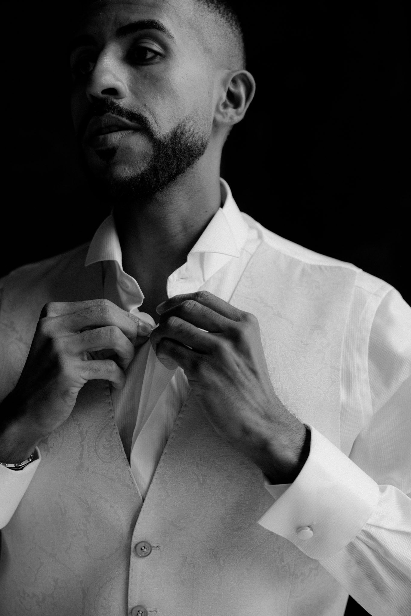 A series of black and white photos showing someone adjusting the collar of a crisp white dress shirt.