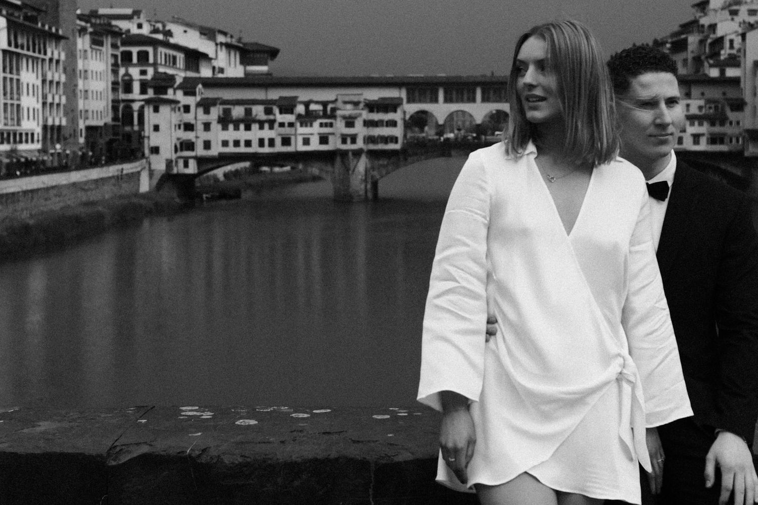A black and white collage of people in white shirts posing against a waterfront backdrop.
