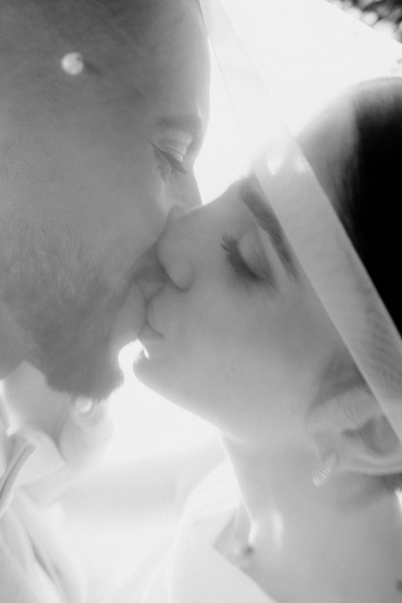 A romantic black and white photo sequence showing a tender kiss between two people in soft focus.