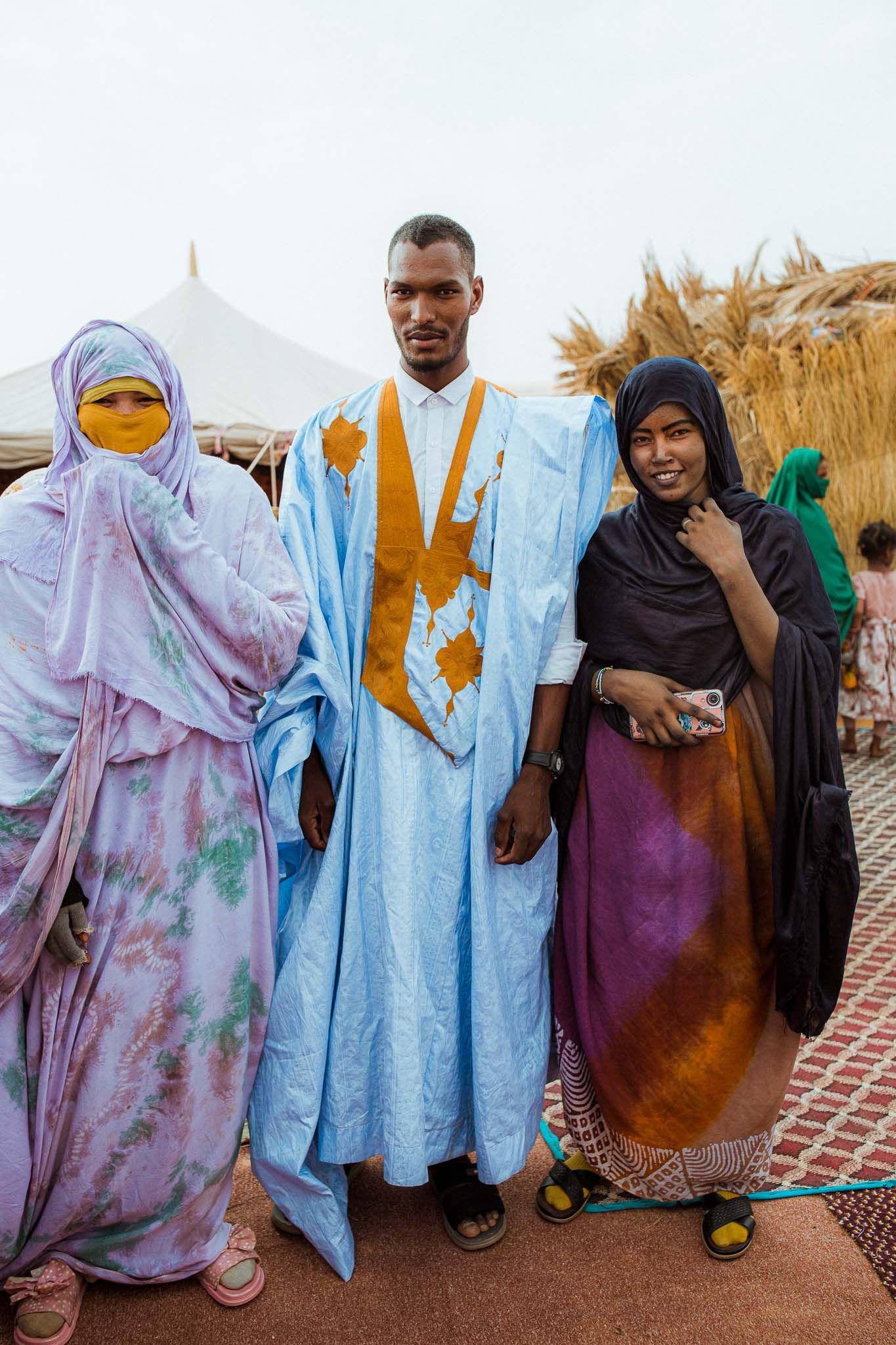 Group of people in traditional African robes and garments standing together outdoors.
