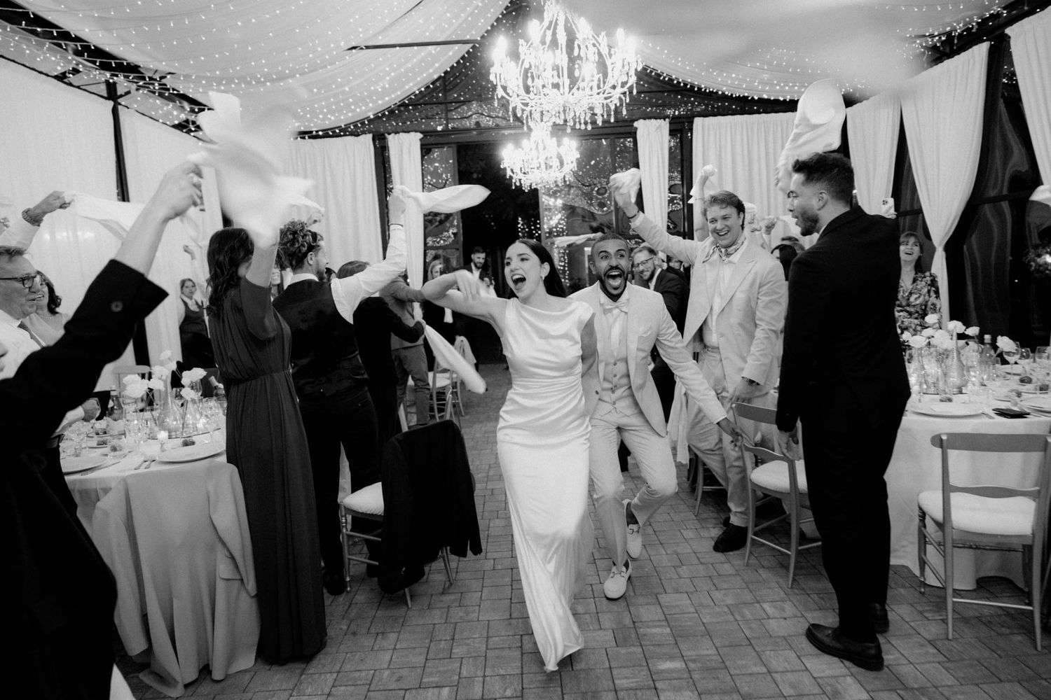 Black and white photos of wedding guests dancing and celebrating at a reception party.
