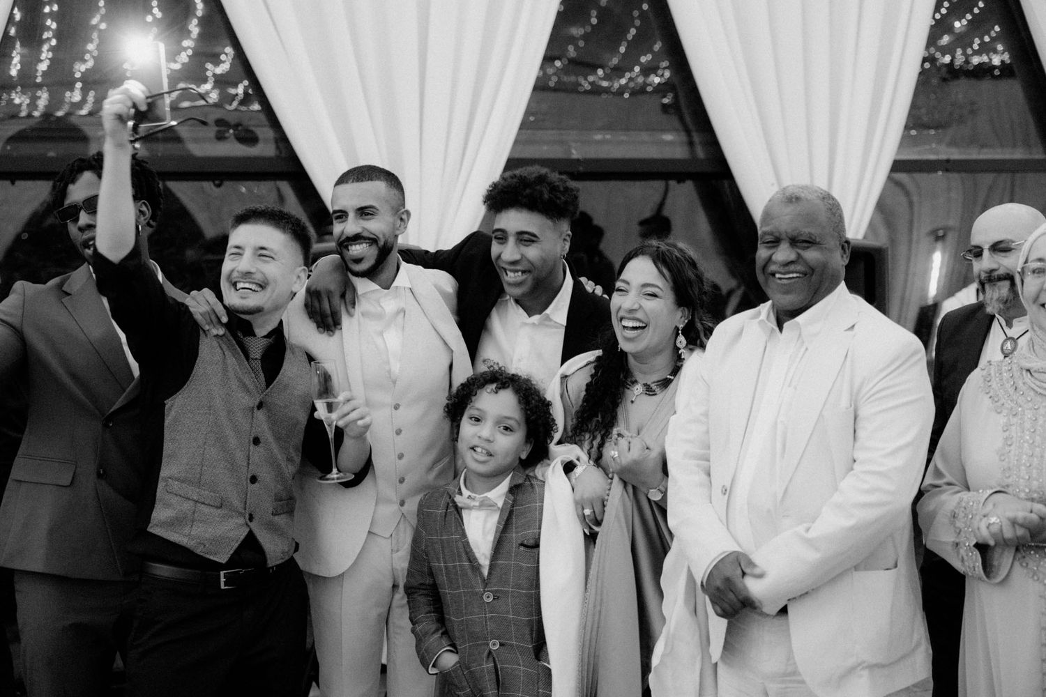 A black and white photo montage showing people laughing and smiling at what appears to be a festive gathering.