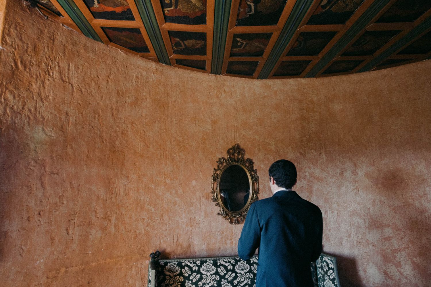 Wedding venue interior with ornate ceiling details and textured terracotta walls.