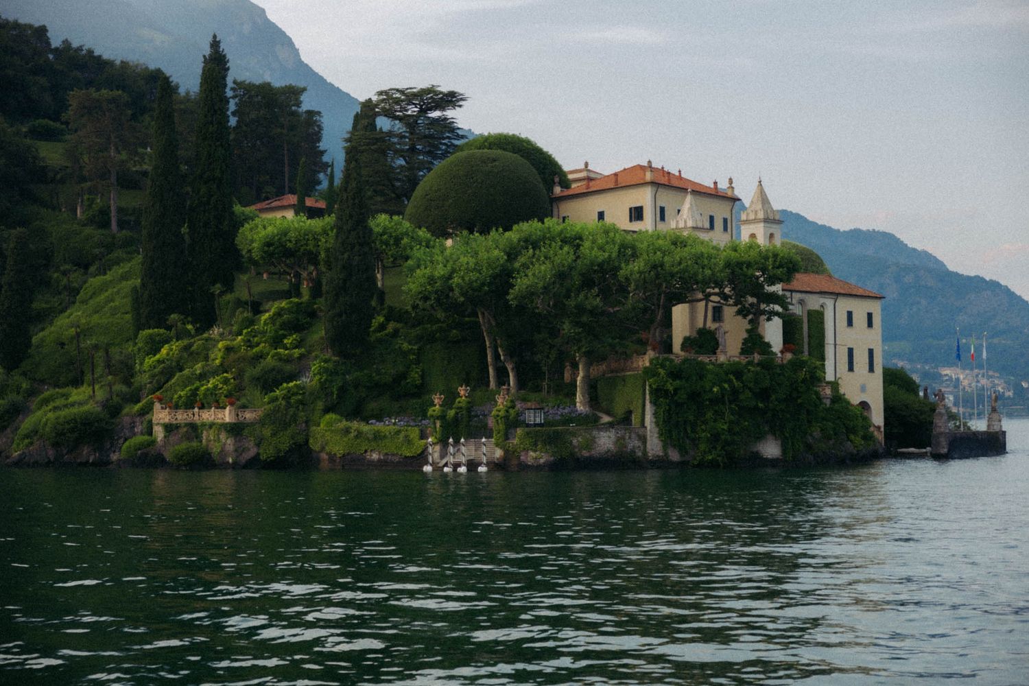 Luxury waterfront villas and historic buildings nestled along Lake Como's tranquil shores in Italy.