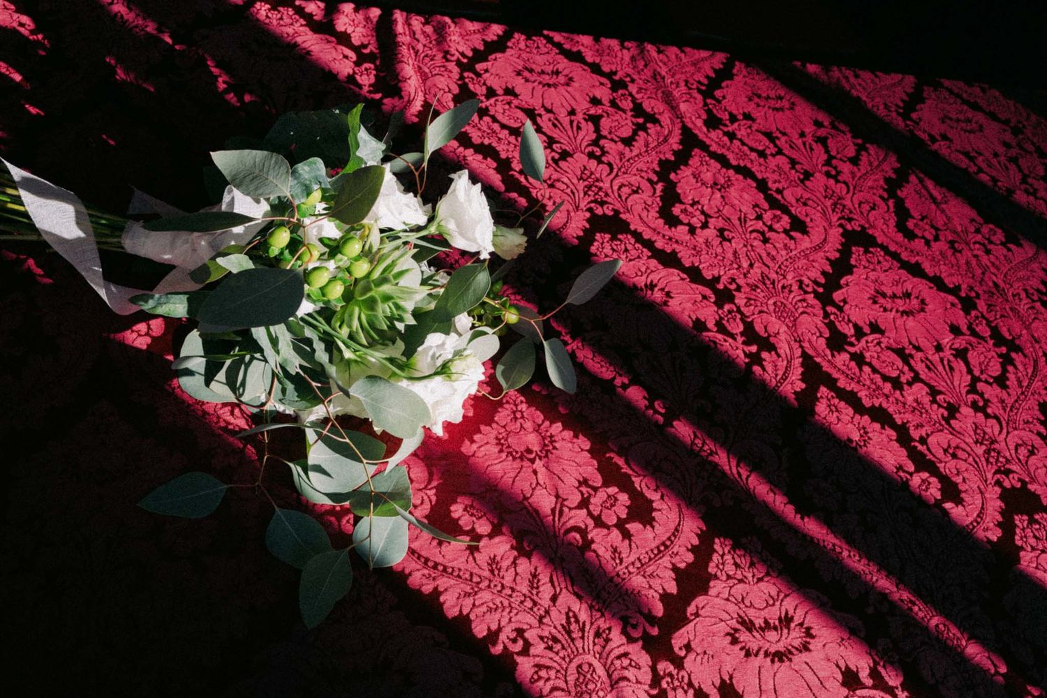 Red floral lace pattern creates an intricate decorative design against a dark background.