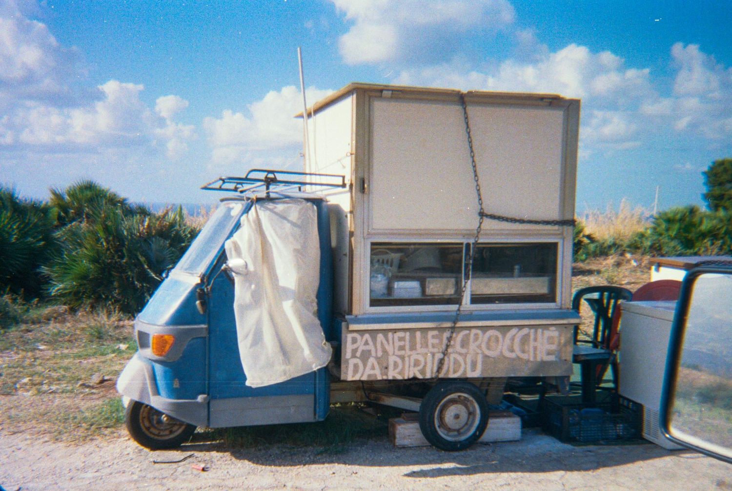 A series of vintage travel trailers and campers parked in a line showing the evolution of recreational vehicles over time.