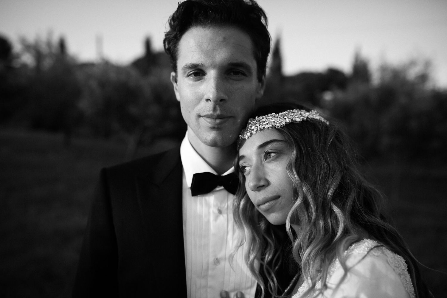 A black and white wedding photo collage showing romantic moments between newlyweds in formal attire.