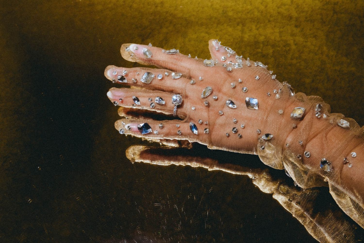 A sequence of macro photos showing water droplets forming and falling from a hand against a dark background.