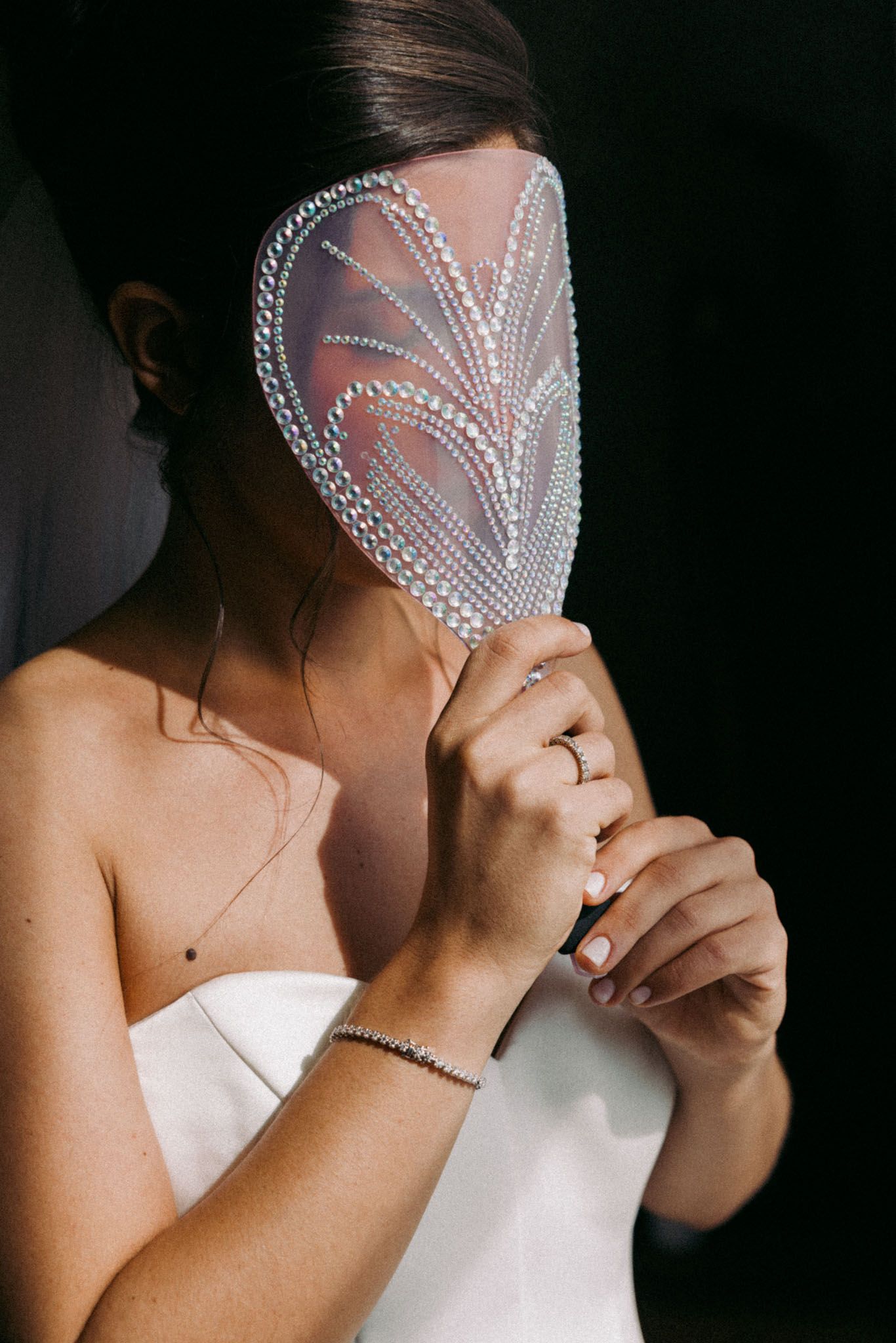 A person adjusts a delicate pearl beaded veil in a series of intimate wedding preparation photos.