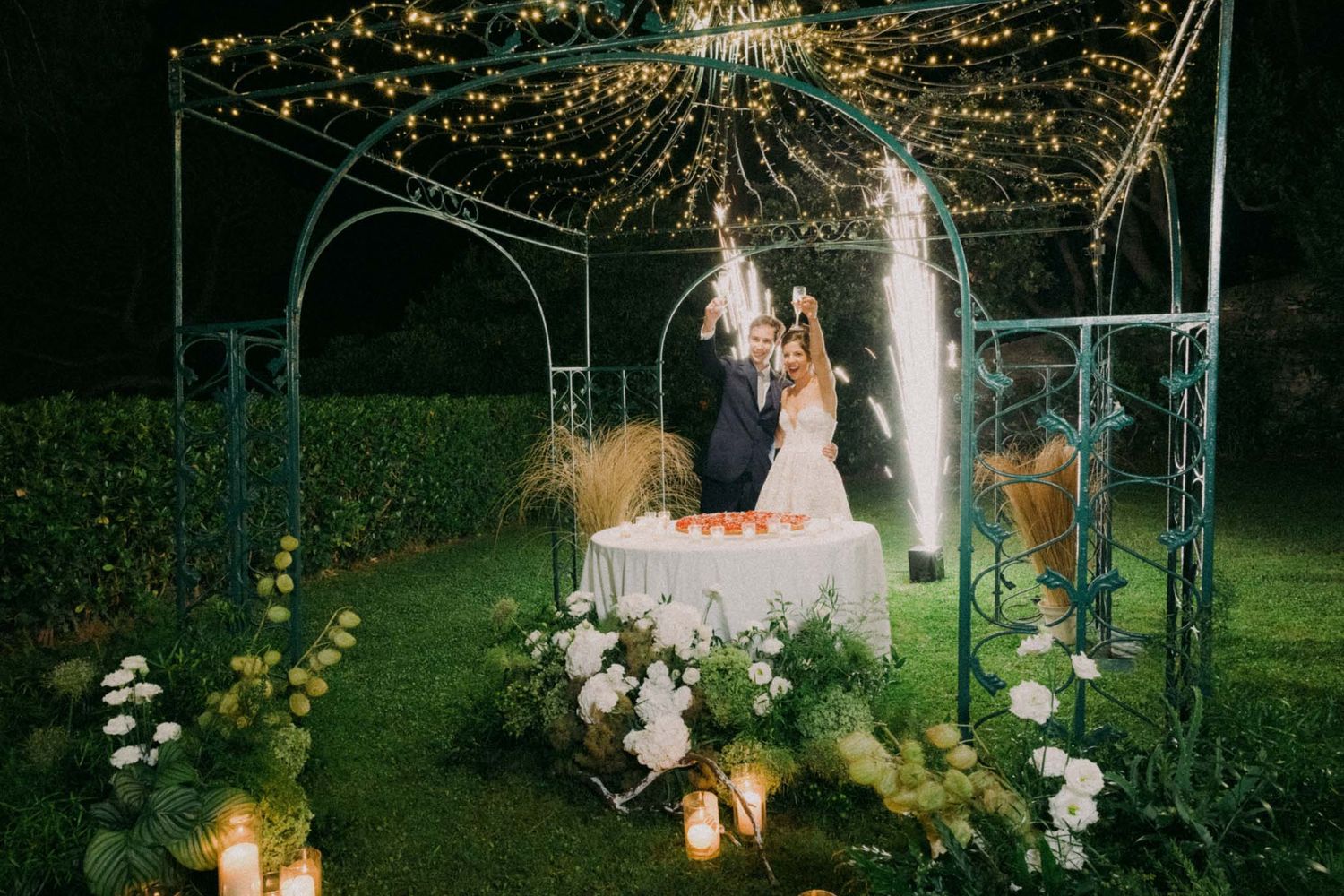 Garden wedding reception setup at night with string lights and lanterns creating a romantic ambiance.