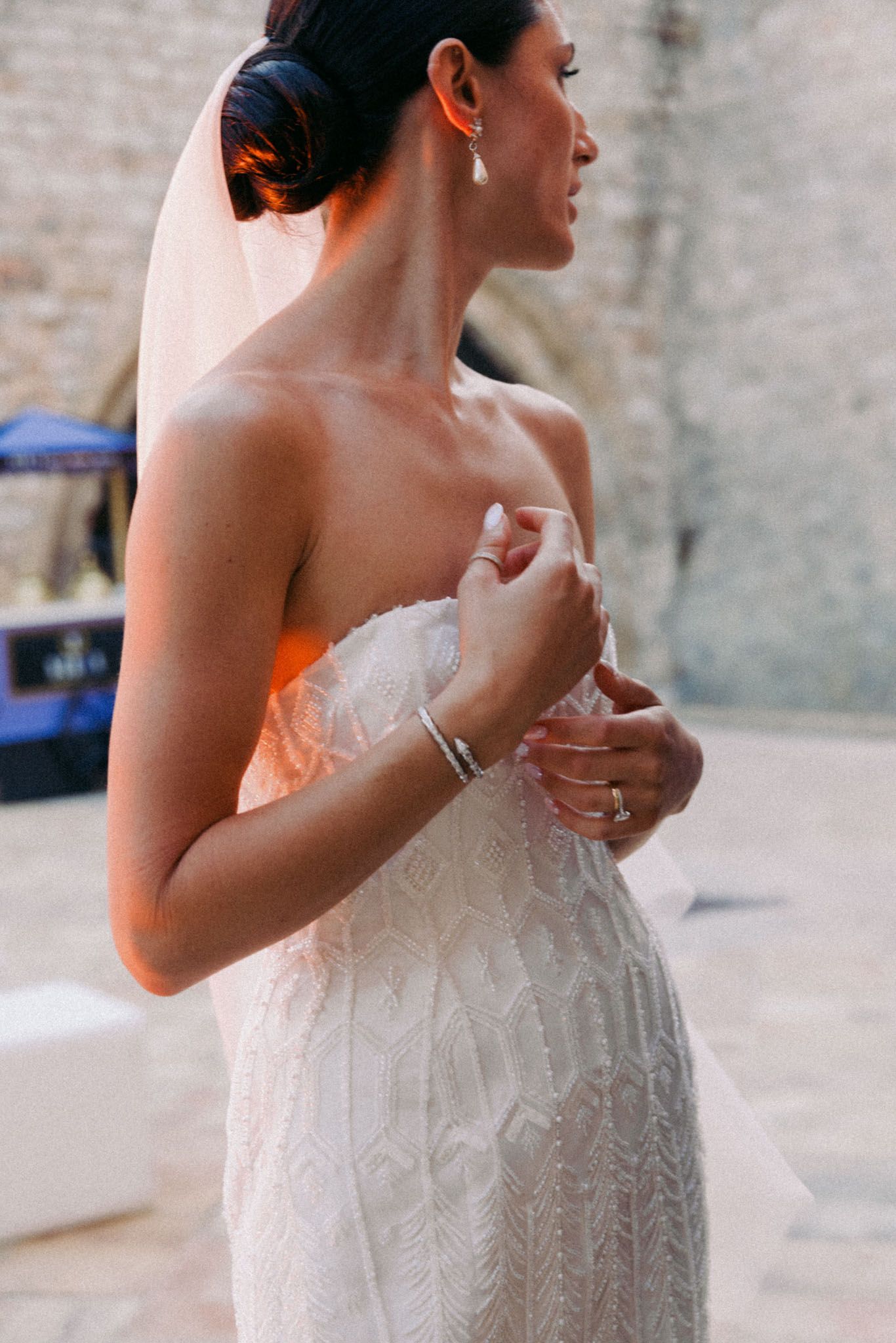 Close-up details of an elegant strapless wedding dress with intricate beaded pattern and textured fabric.