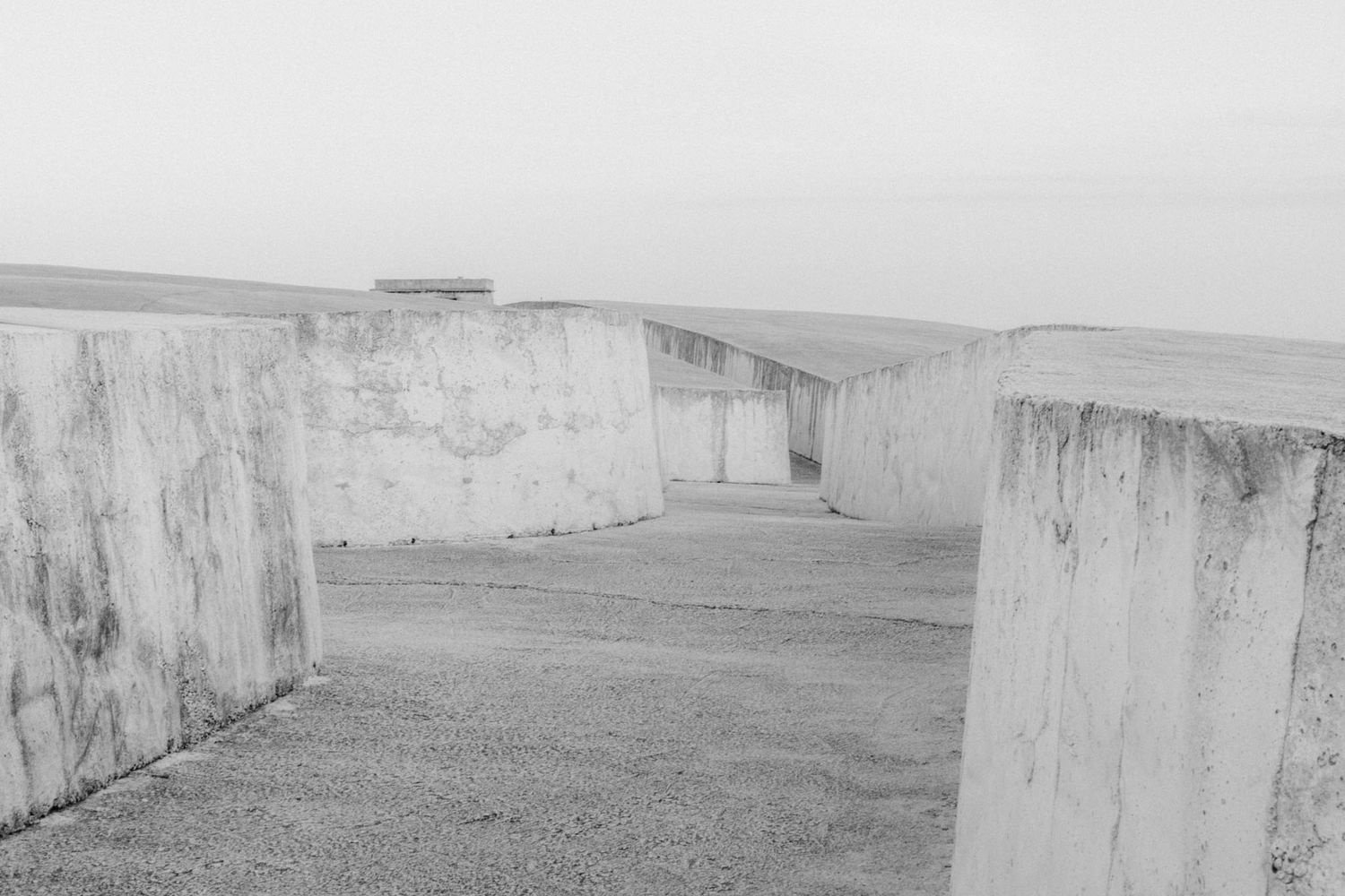 Black and white panoramic view of rolling hills with white cliffs and coastal landscape in the distance.