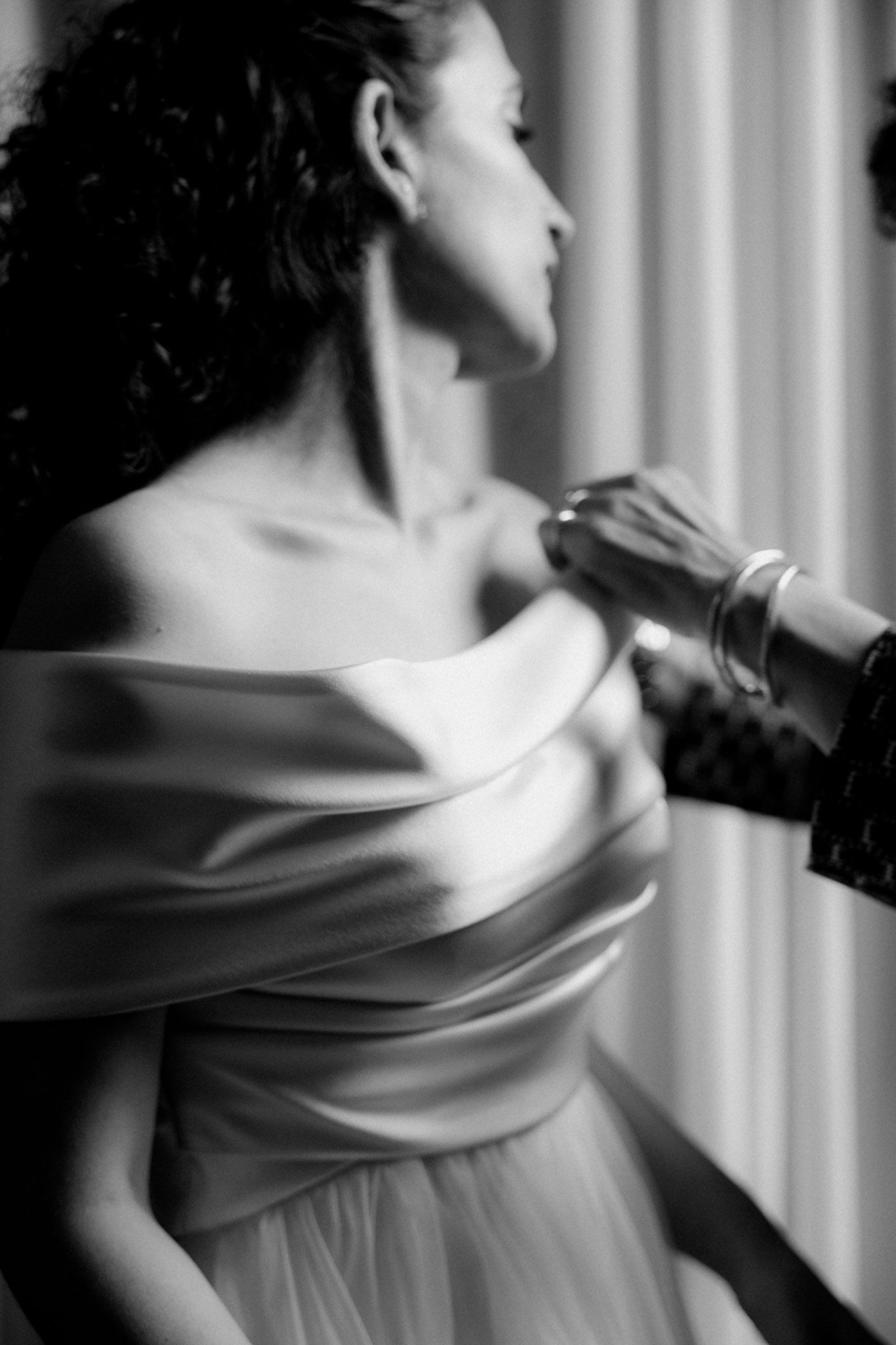 A series of black and white artistic photographs showing the graceful draping of fabric across a person's shoulder.