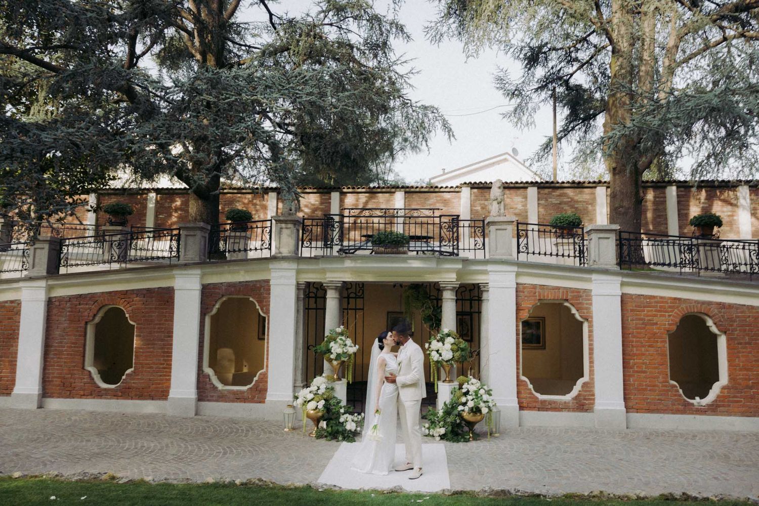 A series of connected photos showing a brick courtyard with arched windows and columns at a historic venue.