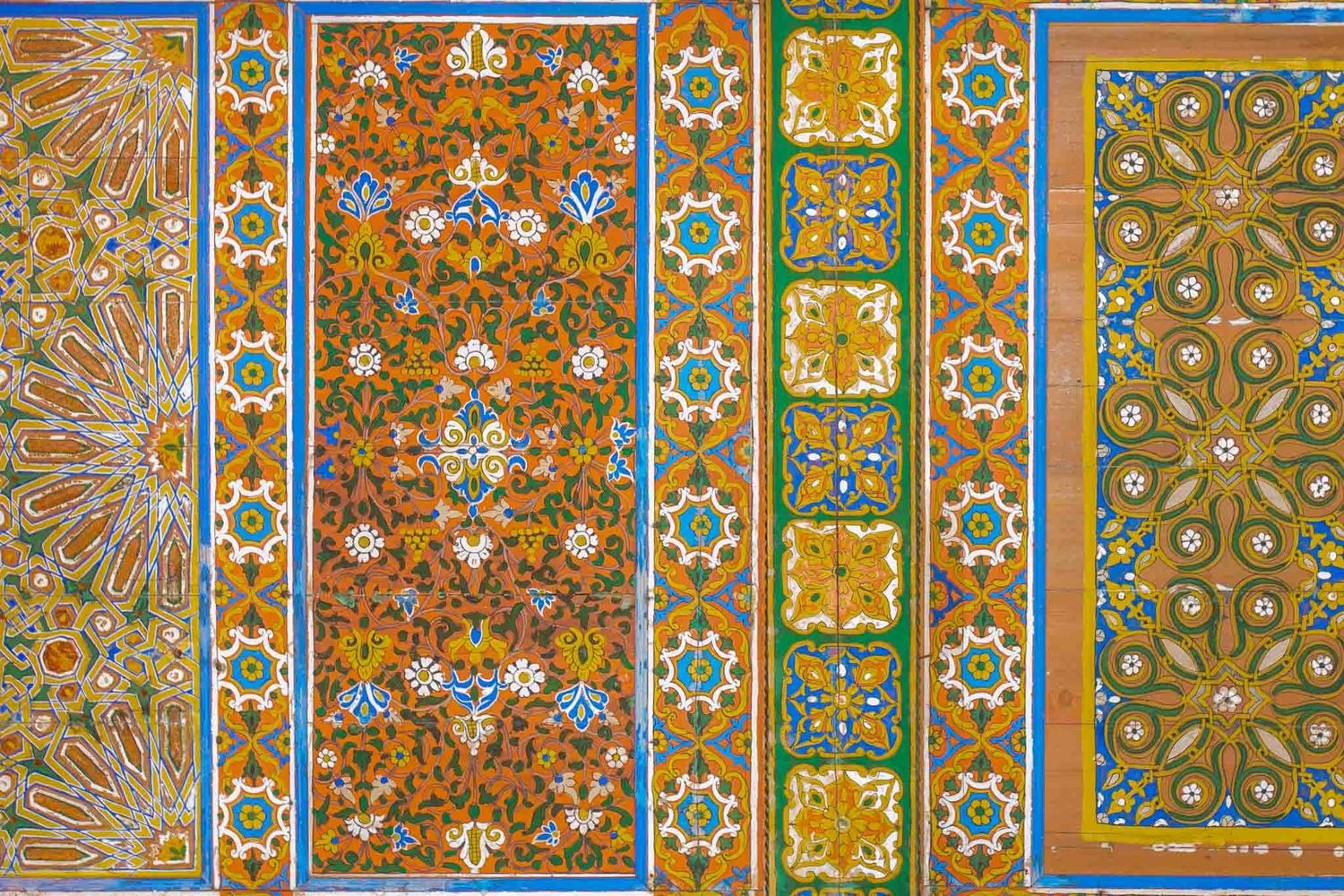 Colorful vintage wallpaper pattern samples featuring ornate floral and geometric designs in orange, green, and blue tones.