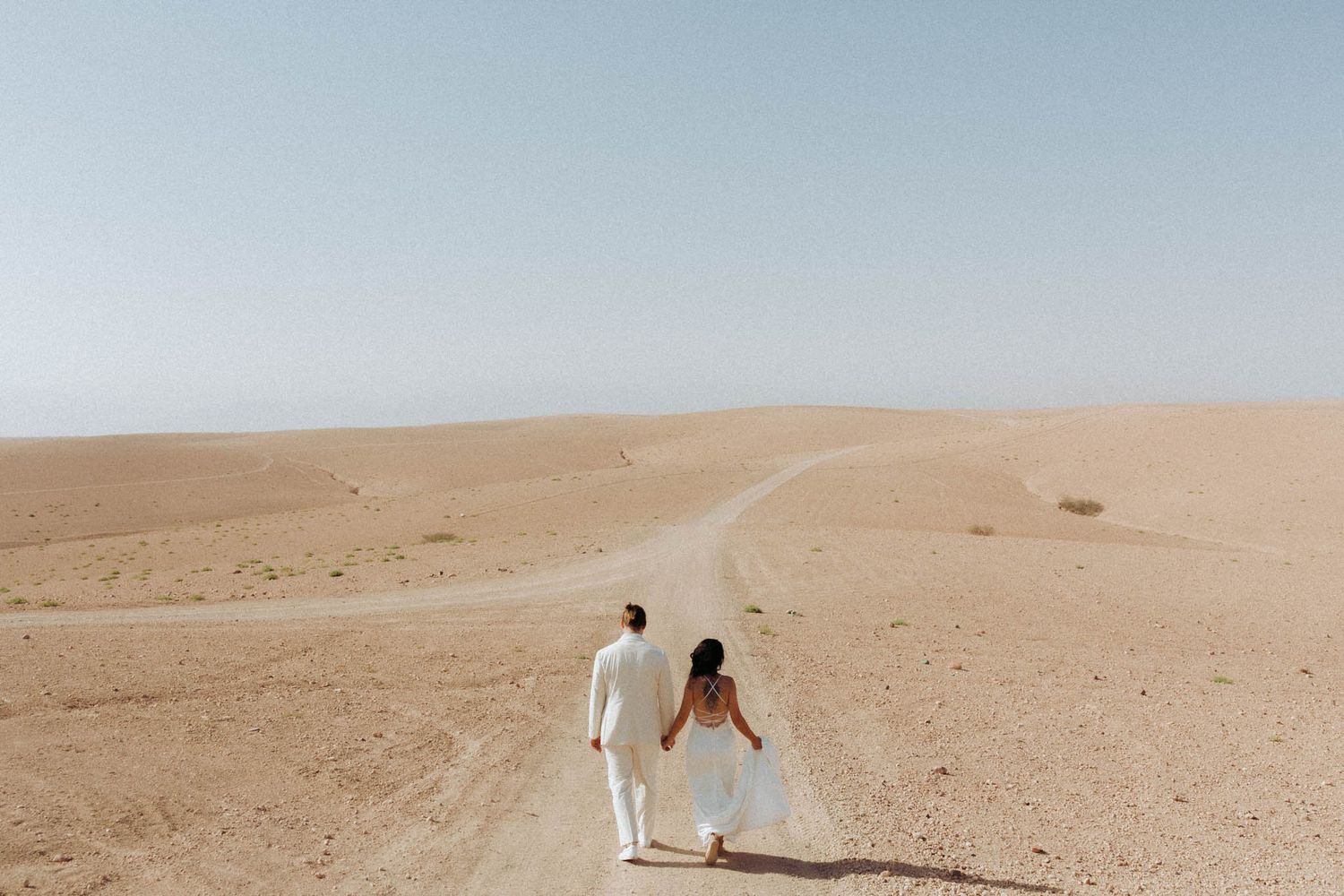A series of desert landscape photos showing sandy dunes and a lone figure walking through vast arid terrain.