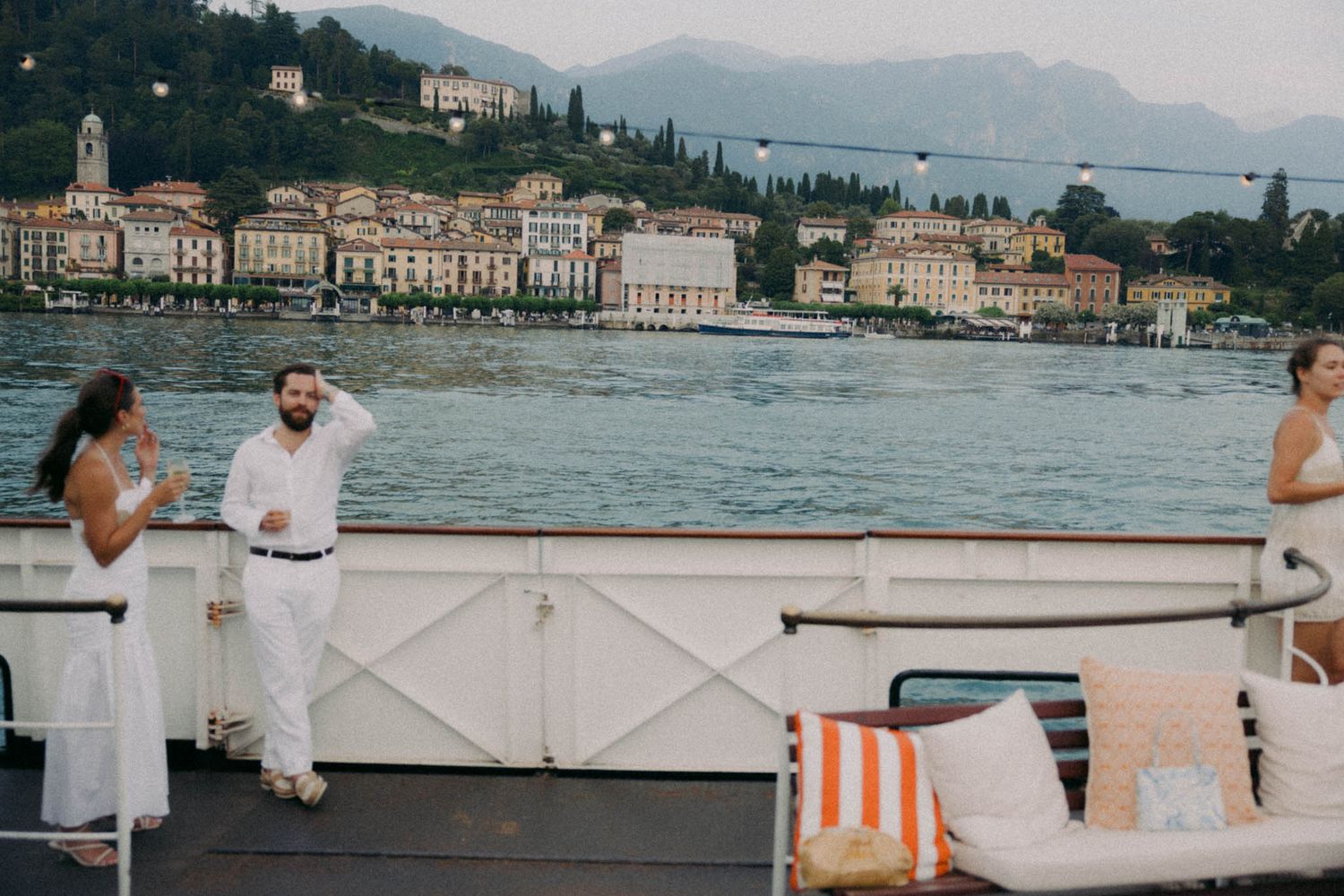 People enjoying a scenic boat ride on Lake Como with the charming waterfront town of Bellagio in the background.