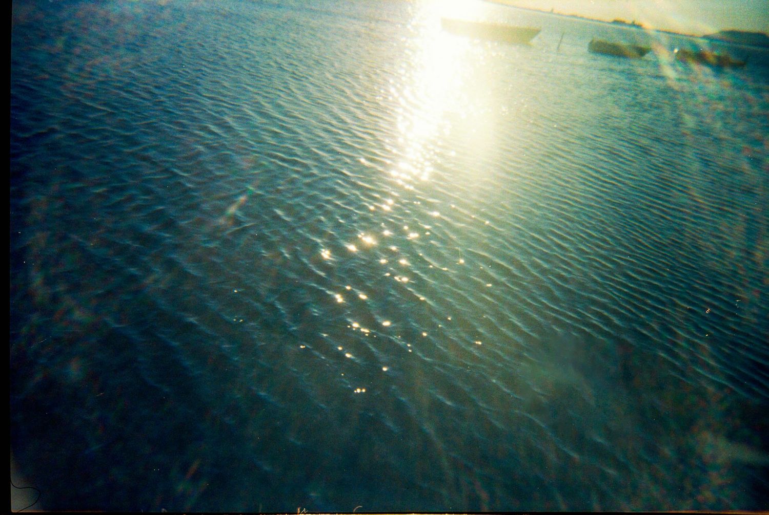 Sunlight reflects off rippling blue ocean water creating a sparkling pattern on the water's surface.